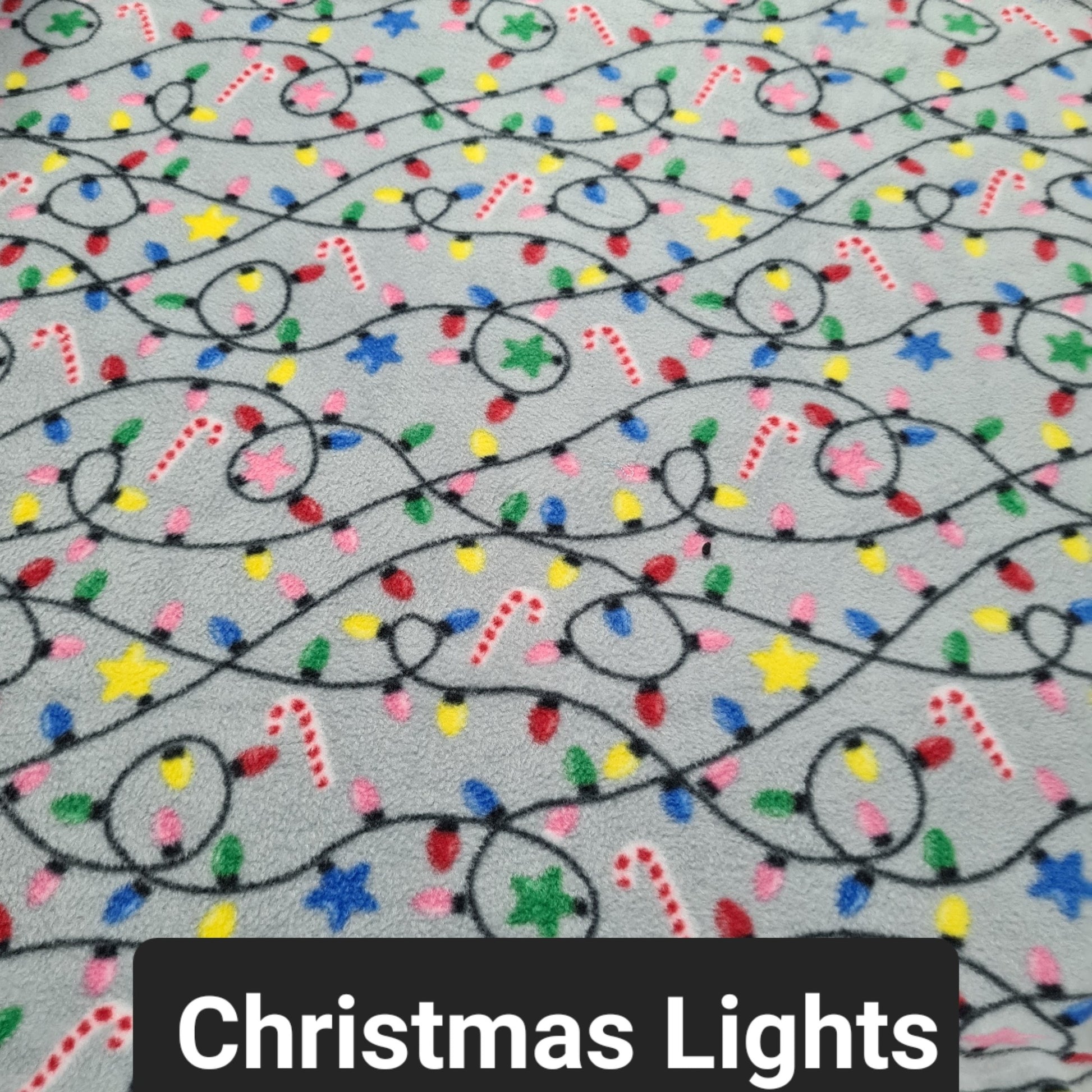 Grey fabric with christmas lights and candy canes
